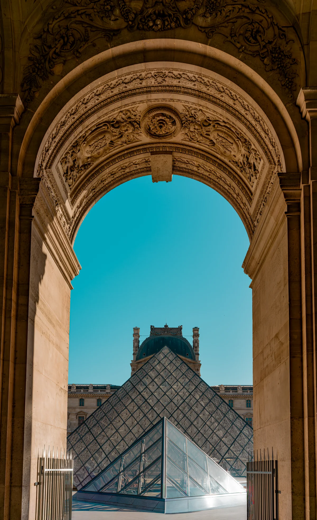 Framing the Louvre — the Louvre pyramids enclosed by an ornate stone arch